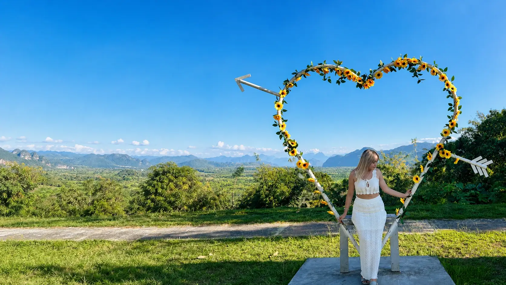 Visitante en el mirador de corazón rodeado de girasoles