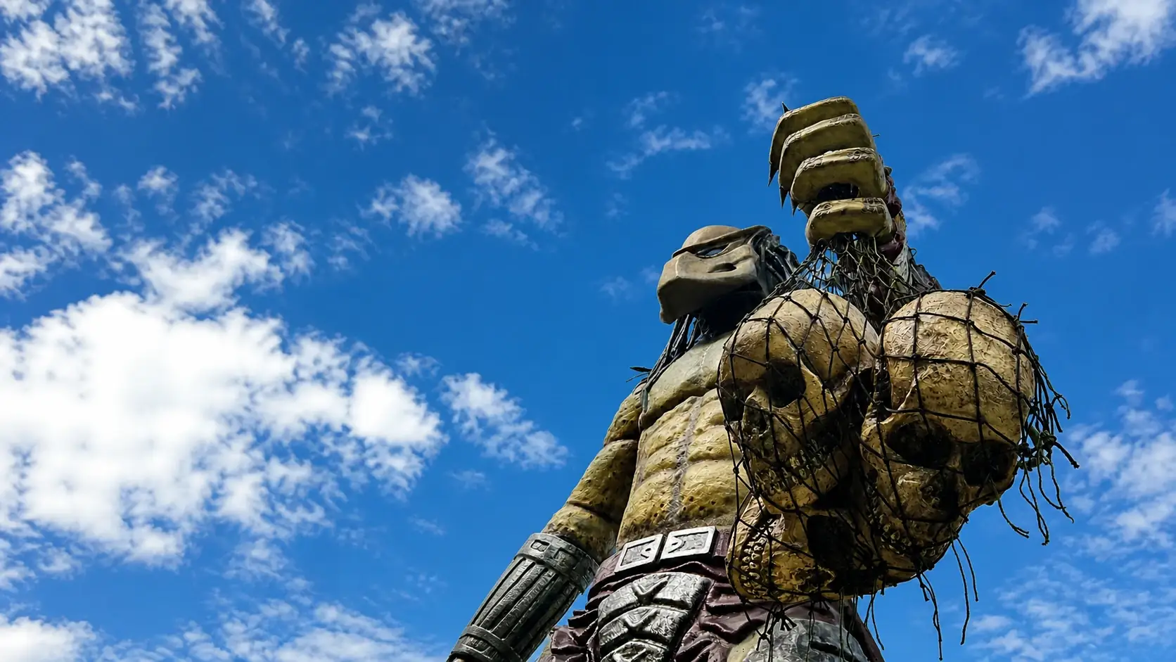 Detalle de la escultura del Depredador entre vegetación tropical