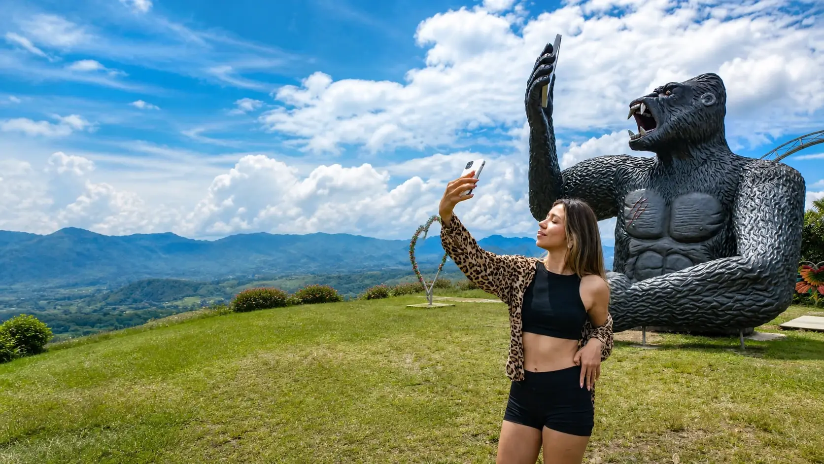 Visitante tomándose una foto junto a la escultura del gorila