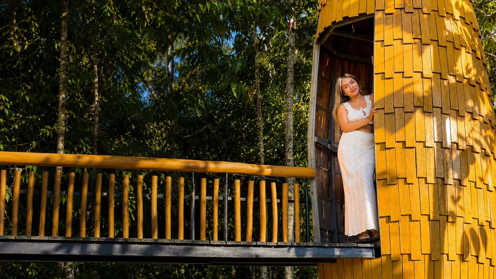 Visitante en una torre de madera elevada entre los árboles